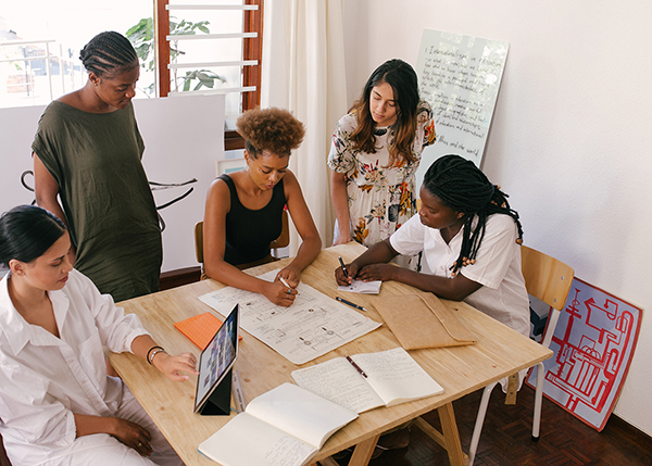 Group of women sitting at a table going over a project